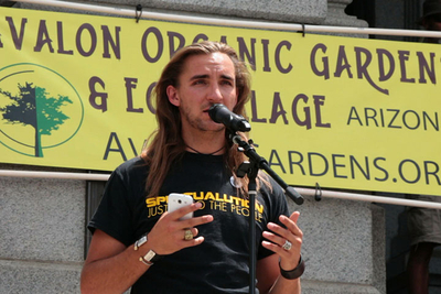 Amadon DellErba speaks on stage at the March Against Monsanto Denver, Colorado protest, sharing a message for food-independence by working cooperatively, creating communities, and growing organic food